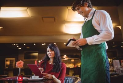 Waiter taking order from woman in a restaurant